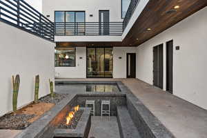 View of patio / terrace with an outdoor fire pit and a balcony