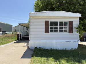 View of property exterior with concrete driveway and a carport