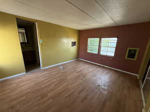 Unfurnished room featuring wood finished floors and baseboards