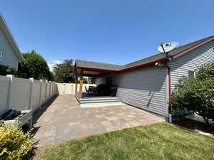 Fenced backyard featuring a patio area and a gate