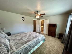 Bedroom with light carpet, baseboards, a textured ceiling, and ceiling fan