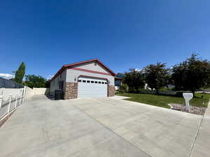 View of property exterior with stone siding and driveway