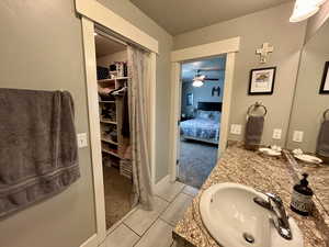 Ensuite bathroom featuring vanity and a closet