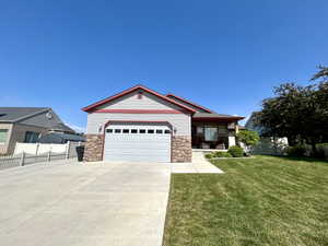 Single story home with driveway, stone siding, an attached garage, and a porch