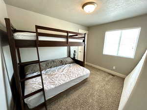 Bedroom featuring a textured ceiling, baseboards, and carpet floors