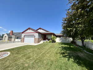 Single story home with stone siding, a garage, and driveway