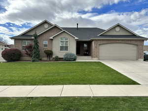 Ranch-style home with driveway, an attached garage, a front yard, brick siding, and a shingled roof