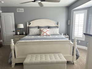 Bedroom with carpet floors, ceiling fan, and baseboards
