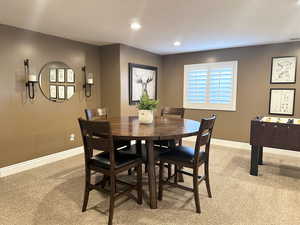 Dining space featuring light carpet, baseboards, and recessed lighting