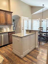 Kitchen with dishwasher, high vaulted ceiling, dark wood-style flooring, backsplash, and pendant lighting