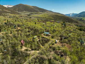 Aerial overview of property's location featuring a mountainous background and property boundaries highlighted