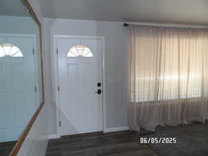 Entrance foyer featuring dark wood-style floors and baseboards