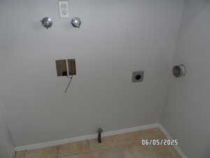 Washroom featuring baseboards, tile flooring, and electric or gas dryer hookup