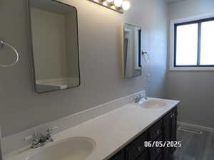 Bathroom with double vanity and baseboards