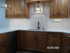 Kitchen featuring a sink, dishwasher, and tasteful backsplash