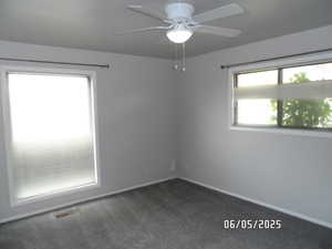 Main bedroom featuring dark carpet, ceiling fan, and baseboards