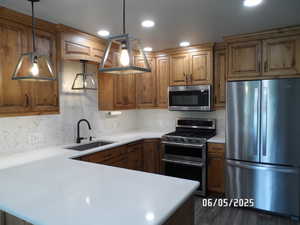 Kitchen featuring appliances with stainless steel finishes, light countertops, decorative backsplash, and recessed lighting