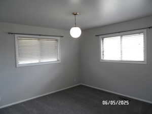 Bedroom with baseboards and dark colored carpet
