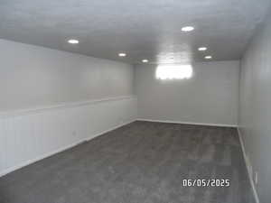 Basement with dark carpet and recessed lighting