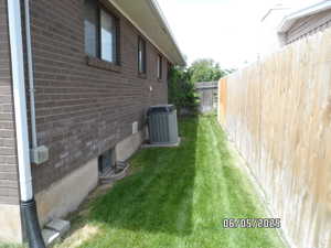 View of property exterior with central AC unit and brick siding