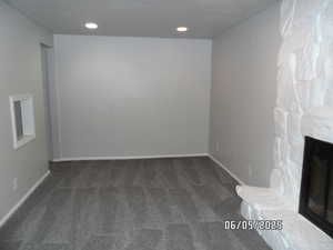 Unfurnished living room/den with carpet floors, baseboards, and recessed lighting