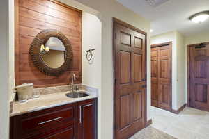 Bathroom featuring vanity, baseboards, and tile patterned floors