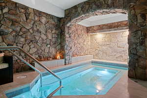 View of pool featuring an in-ground hot tub and a swimming pool