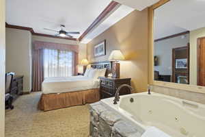 Bedroom with crown molding, carpet, a ceiling fan, and baseboards