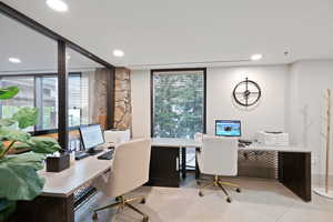 Office space featuring plenty of natural light, floor to ceiling windows, recessed lighting, and light tile patterned floors