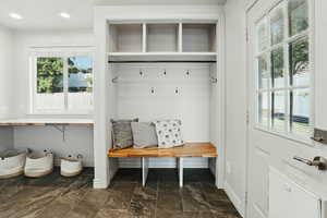 Mudroom with plenty of natural light, baseboards, dark stone finish flooring, and recessed lighting