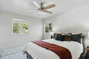 Bedroom featuring multiple windows, baseboards, carpet, and a ceiling fan