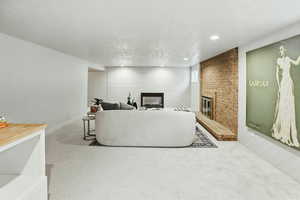 Living room with a fireplace, carpet floors, recessed lighting, and baseboards