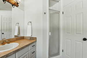 Full bath with a stall shower and vanity
