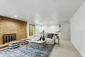 Carpeted living area with a fireplace, baseboards, and recessed lighting
