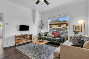 Living area with a ceiling fan, wood finished floors, and baseboards