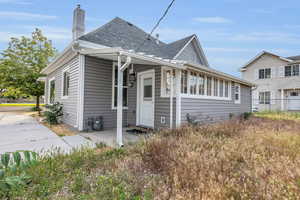 View of front of house featuring roof with shingles and a chimney