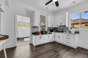 Kitchen featuring a ceiling fan, tasteful backsplash, dark wood-style floors, and dark stone counters