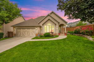 View of front of house with stucco siding, and garage.