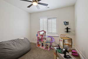 Game room with ceiling fan, carpet, and baseboards
