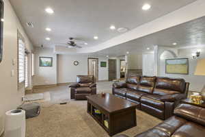 Carpeted living area with recessed lighting, baseboards, ceiling fan, and a textured ceiling