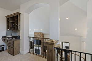 Home office with carpet floors and arched walkways