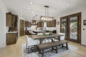 Dining area with a chandelier, recessed lighting, light wood-style floors, and baseboards