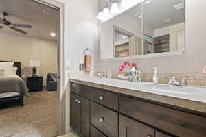 Bathroom featuring ensuite bathroom, double vanity, a ceiling fan, and recessed lighting