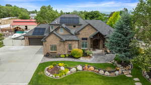 Craftsman-style house featuring concrete driveway, a shingled roof, a gate, and solar panels