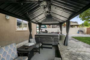 View of patio / terrace featuring a hot tub and a gazebo
