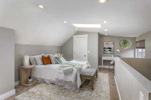 Bedroom featuring light carpet, vaulted ceiling, a skylight, baseboards, and recessed lighting