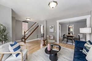 Living area with wood finished floors, stairway, healthy amount of natural light, baseboards, and a textured ceiling