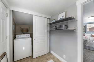Washroom featuring washer / clothes dryer and a textured ceiling