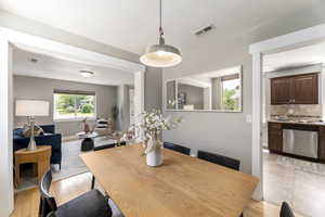 Dining area with baseboards, light wood-style floors, and a textured ceiling