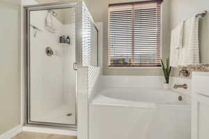 Full bathroom featuring a garden tub and a stall shower